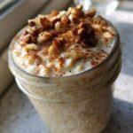 Close-up of creamy apple cinnamon overnight oats topped with chopped walnuts and cinnamon.