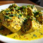 Close-up of tender pieces of coconut lime chicken coated in a rich, yellow coconut sauce and topped with fresh cilantro.