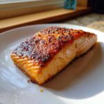 A juicy, perfectly cooked fillet of air fryer salmon with a beautifully caramelized and seasoned top crust.