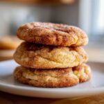 A stack of three soft, chewy snickerdoodles cookies coated generously in cinnamon sugar.