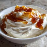 A close-up of creamy whipped ricotta dip topped generously with glistening hot honey.