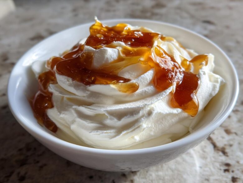 A close-up of creamy whipped ricotta dip topped generously with glistening hot honey.