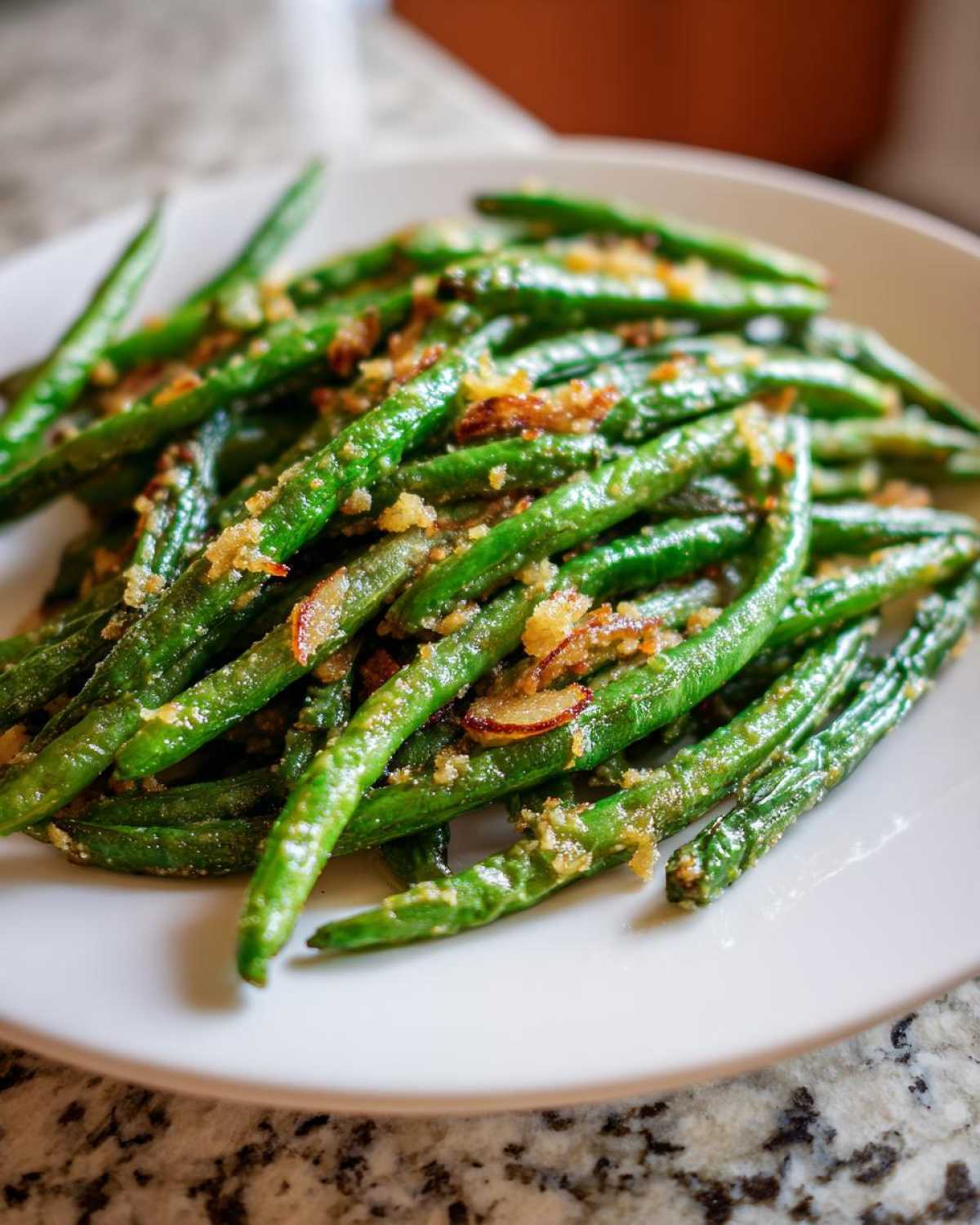 A close-up of bright green beans topped with crispy breadcrumbs and caramelized onions, showcasing the amazing 32-minute green beans recipe.