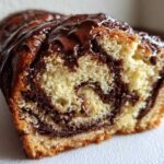 A close-up cross-section view showing the rich swirls of chocolate filling inside a freshly baked chocolate babka loaf.