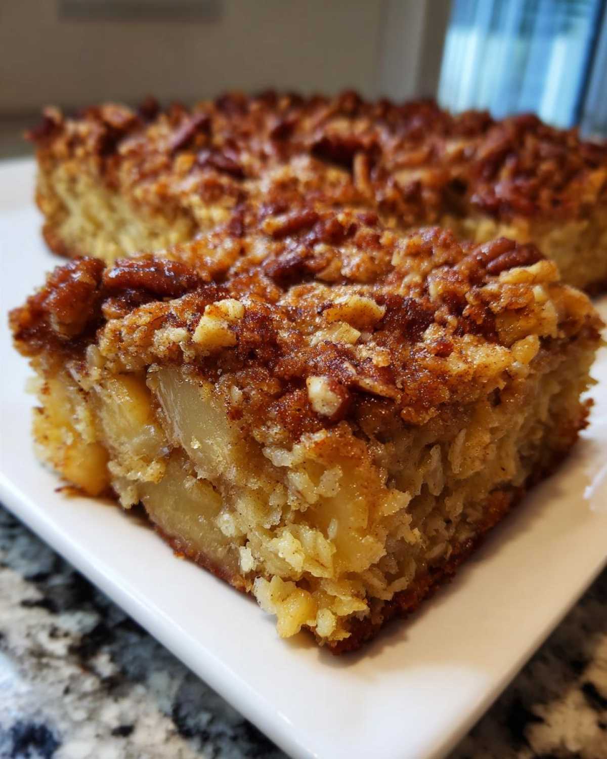 Close-up of a moist slice of baked oatmeal topped with cinnamon crumble and pecans.