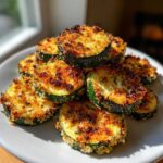A stack of perfectly golden brown baked parmesan zucchini slices with a crispy topping.