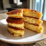 A stack of fluffy coconut flour pancakes, cut to show the light, airy interior texture.