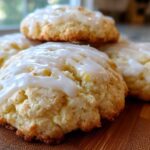 Close-up of several soft, baked ricotta cookies topped with a thick white glaze.