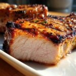 Close-up of a perfectly cooked, juicy pork chop showing the moist interior after using the best marinade for pork chops.