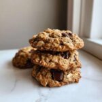 A stack of three chewy oatmeal cookie treats featuring visible oats and large chocolate chunks.
