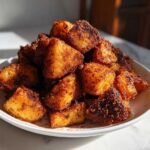 A mound of golden, crispy Air Fryer Crispy Breakfast Potatoes with Paprika piled high on a white plate.