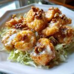 Close-up of Copycat Panda Express Honey Walnut Shrimp, glazed and topped with walnuts, served over shredded lettuce.
