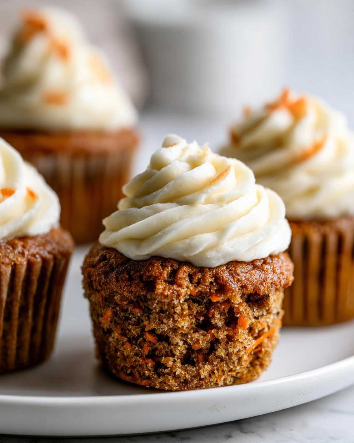 Close-up of a moist Gluten-Free Carrot Cake Cupcakes topped with thick cream cheese frosting.