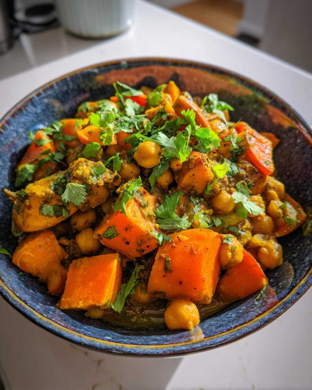 Close-up of Instant Pot Moroccan Chickpea Stew with large chunks of sweet potato and chickpeas, topped with fresh cilantro.