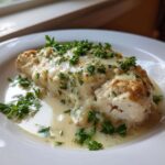 A serving of Keto Creamy Garlic Herb Chicken Bake, smothered in a rich sauce and topped with fresh parsley.