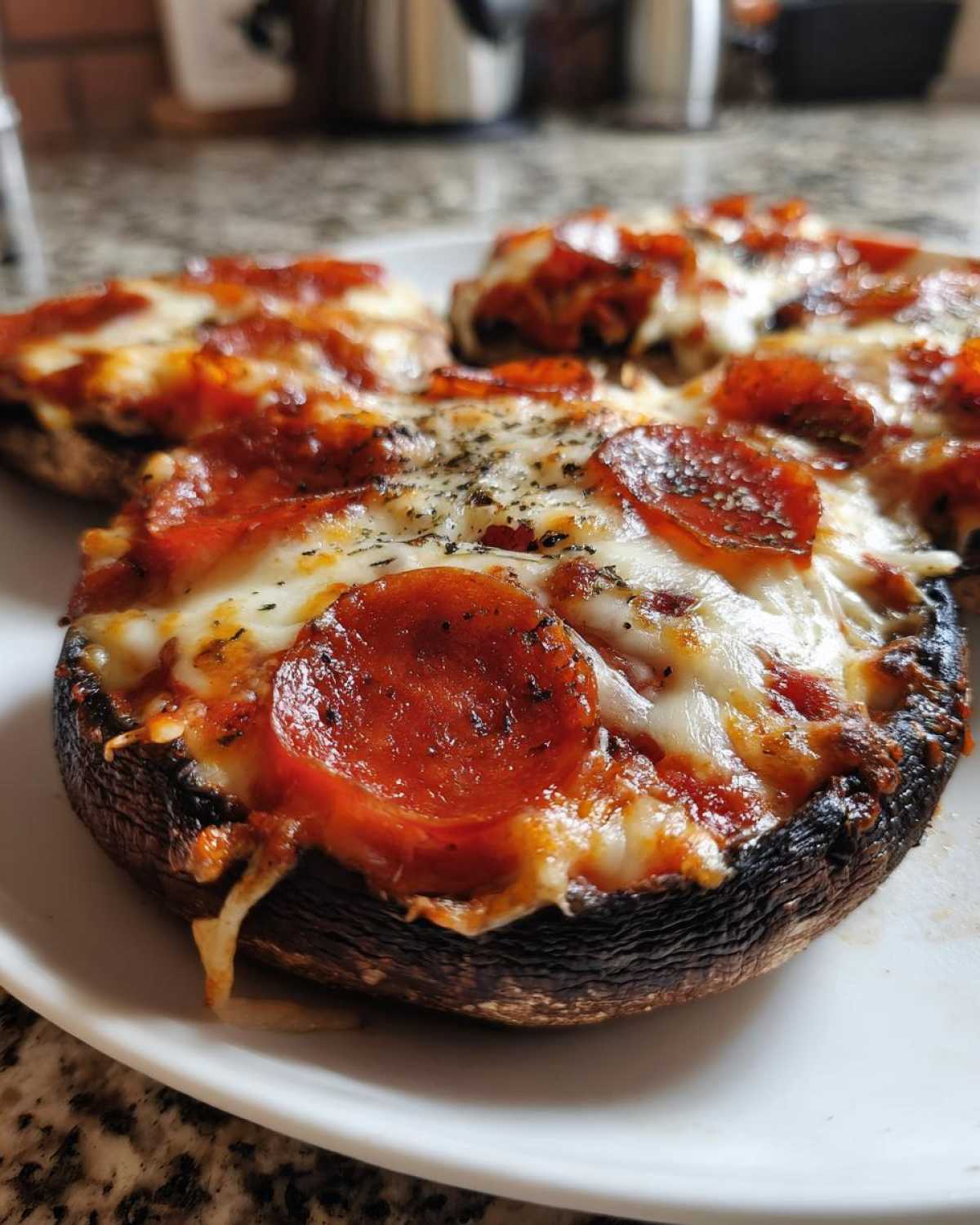 Close-up of baked Keto Pizza Stuffed Portobello Mushrooms topped with melted cheese and pepperoni.