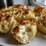 Close-up of baked Cheesy Chicken Alfredo Stuffed Pasta Shells with golden-brown melted cheese topping.