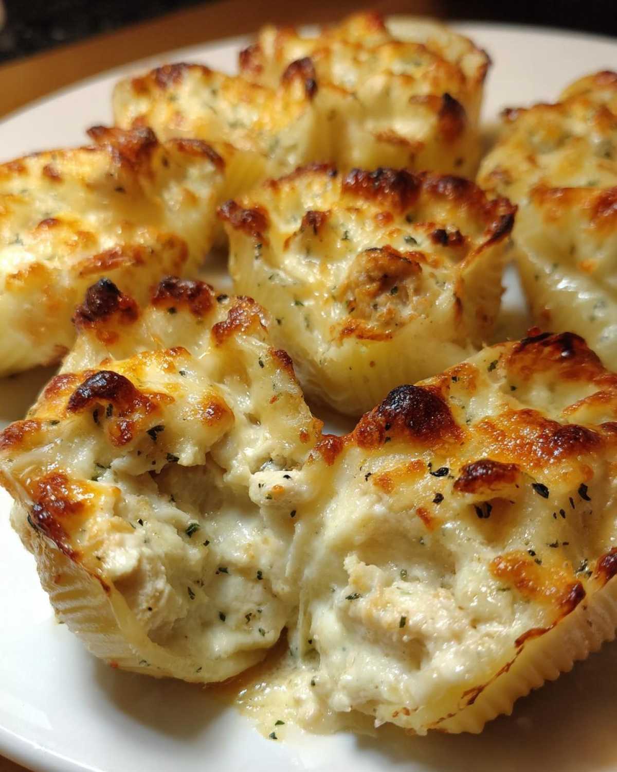 Close-up of baked Cheesy Chicken Alfredo Stuffed Pasta Shells with bubbly, browned cheese topping.