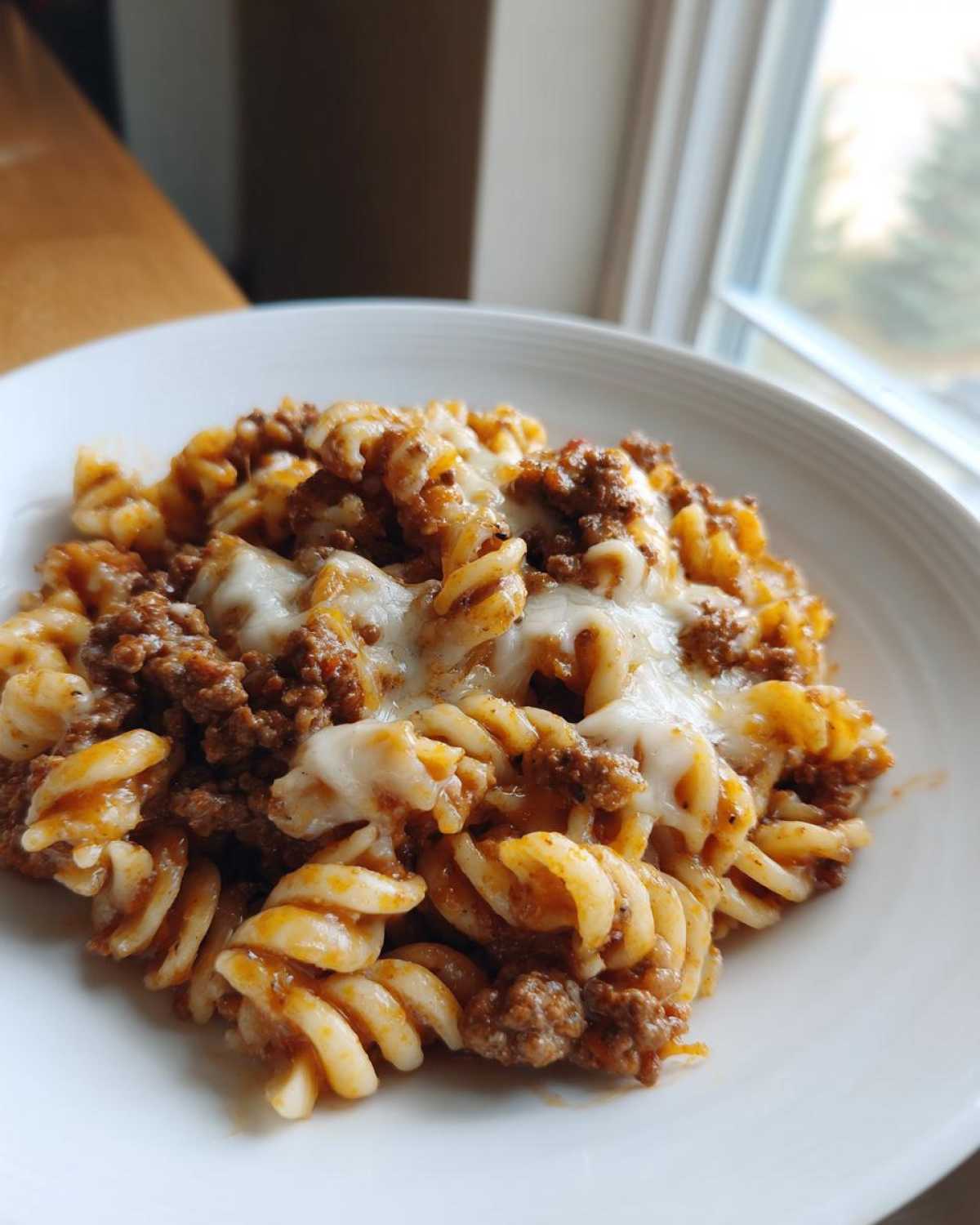 A close-up of Cheesy Ground Beef Pasta Skillet featuring rotini pasta, rich meat sauce, and melted mozzarella cheese.