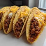 Four crispy tacos filled with seasoned ground beef, creamy filling, and melted cheddar cheese, showcasing the Cheesy Ground Beef Tacos filling.