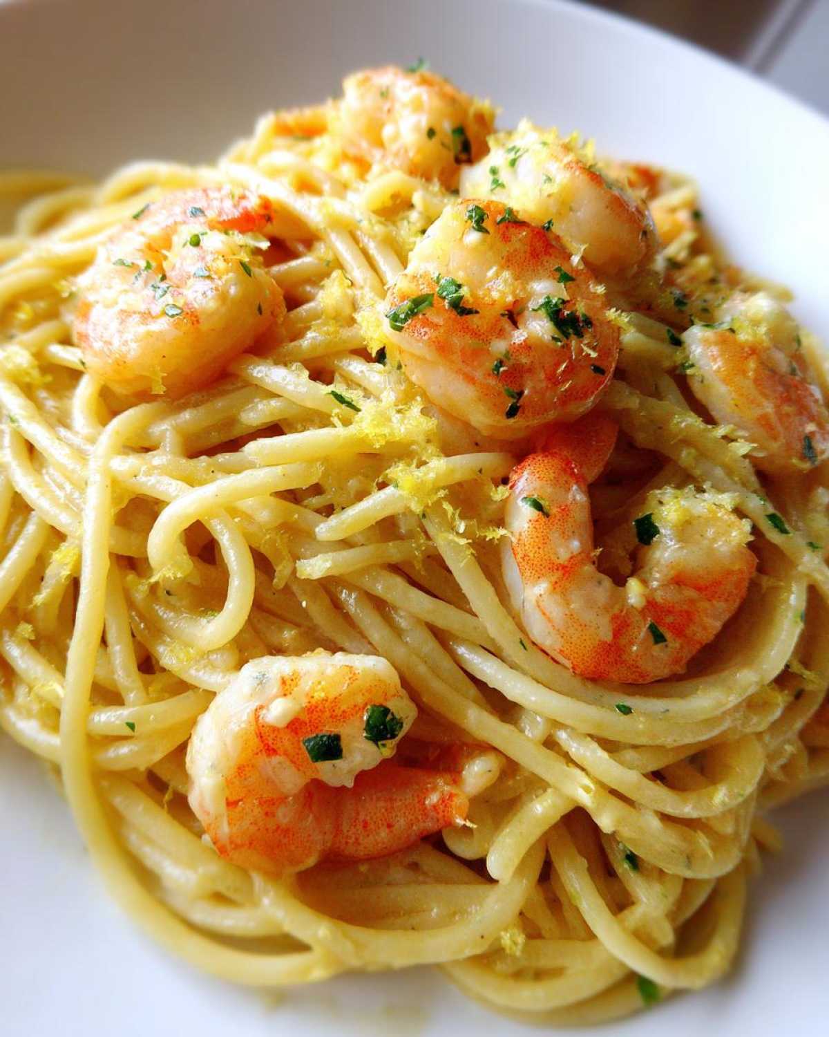 Close-up of a serving of Creamy Lemon Shrimp Pasta with Garlic Sauce, topped with plump shrimp and lemon zest.