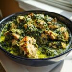 Close-up of seared chicken pieces coated in a rich, green sauce in a Creamy Spinach Chicken Skillet with Parmesan.