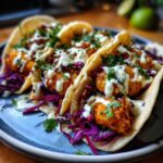 Three delicious Crispy Chicken Tacos filled with golden fried chicken, purple cabbage slaw, and drizzled with creamy Garlic Lime Sauce.
