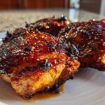 Close-up of three Honey Soy Chicken Thighs with crispy, caramelized edges and a shiny glaze.