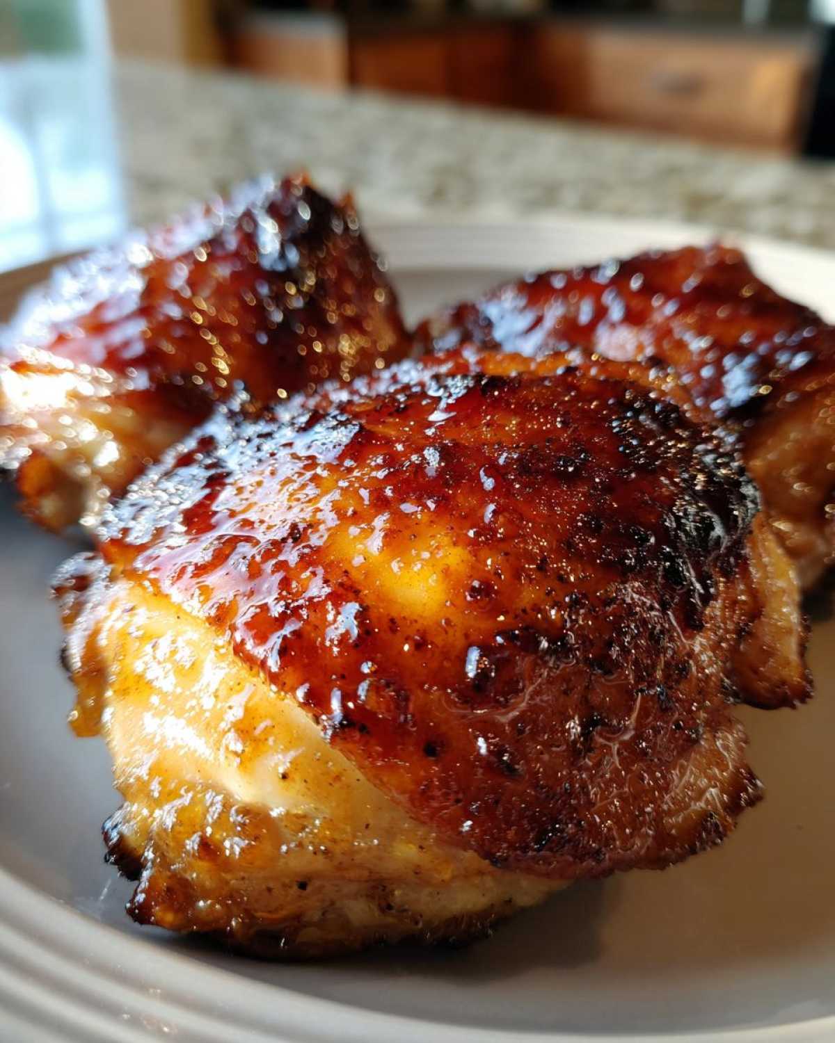 Close-up of three pieces of Honey Soy Chicken Thighs with crispy, caramelized edges and a glossy glaze.