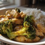 A white bowl filled with Garlic Butter Chicken and Broccoli Stir Fry served next to a mound of white rice.