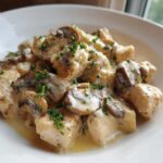 Close-up of tender chicken pieces and sliced mushrooms in a creamy garlic butter sauce, garnished with parsley, from the Garlic Butter Chicken and Mushroom Skillet Dinner.