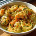 Close-up of succulent Garlic Butter Shrimp with Creamy Parmesan Sauce, garnished with parsley, served in a white bowl.