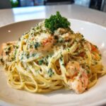 A close-up of rich Garlic Butter Shrimp Pasta with Cream Sauce, topped with parsley and Parmesan cheese.