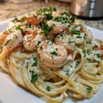 Close-up of creamy Garlic Butter Shrimp Pasta topped generously with cooked shrimp and fresh parsley.