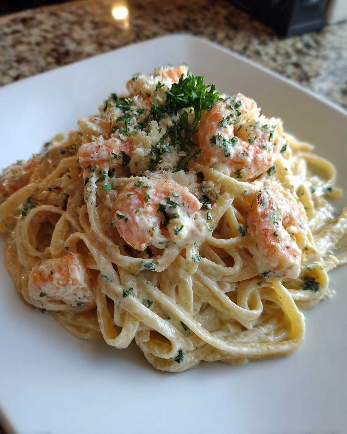 A close-up of creamy Garlic Butter Shrimp Pasta with fettuccine, topped with shrimp, Parmesan, and parsley.