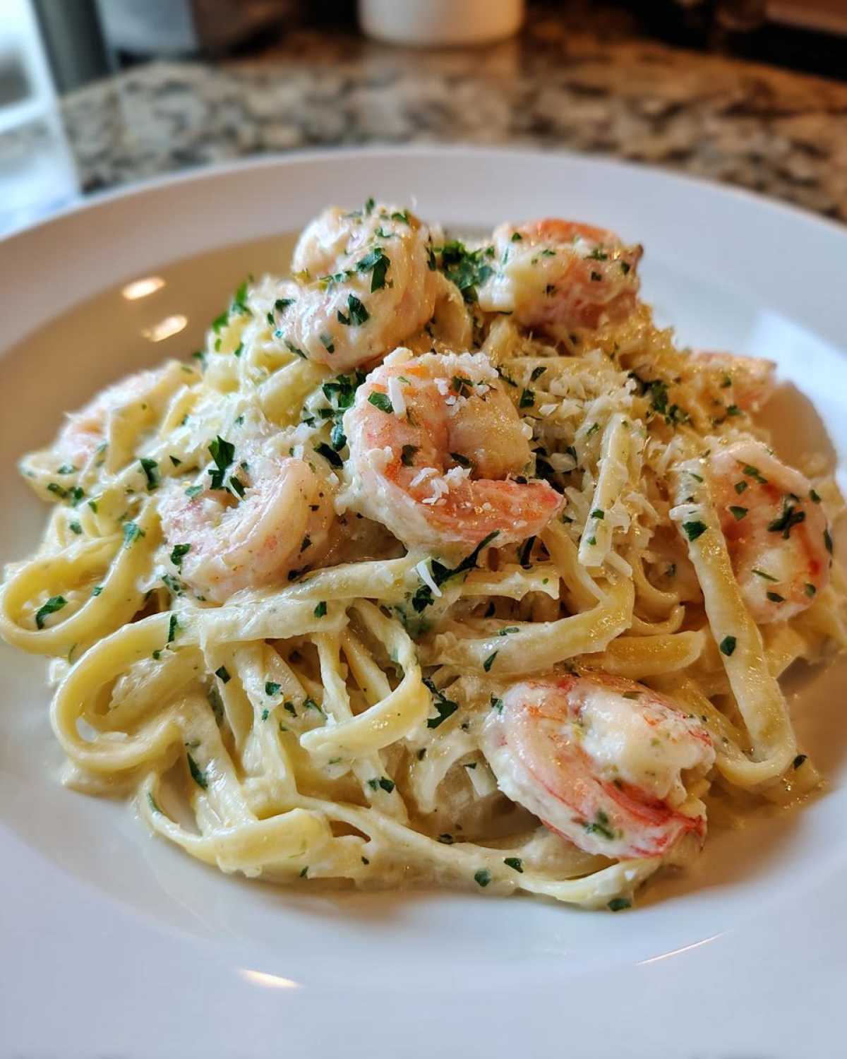 Close-up of Garlic Butter Shrimp Pasta with Cream Sauce, topped with shrimp and parsley.