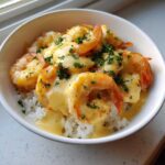 A close-up of a Garlic Butter Shrimp Rice Bowl topped with rich garlic sauce and fresh parsley.