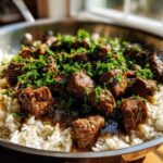 Close-up of Garlic Butter Steak and Rice Skillet Dinner, featuring browned steak cubes over white rice, topped with fresh parsley.