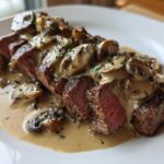 Perfectly cooked Garlic Butter Steak with Creamy Mushroom Sauce, sliced to show medium-rare interior.