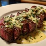 Slices of medium-rare steak topped with a rich, creamy Garlic Butter Steak with Creamy Sauce and fresh parsley.