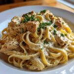 Close-up of Honey Garlic Chicken Pasta with Cream Sauce, featuring fettuccine noodles and cubed chicken breast topped with parsley.