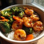 Close-up of a Honey Garlic Shrimp Bowl Quick Dinner featuring glazed shrimp, bright green broccoli, and sliced carrots over white rice.