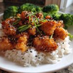 Close-up of Honey Soy Garlic Chicken pieces glazed in sauce, served over white rice with steamed broccoli.