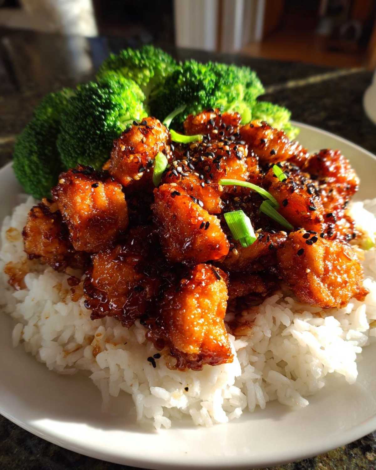 Close-up of Honey Soy Garlic Chicken with rice and steamed broccoli, topped with sesame seeds.